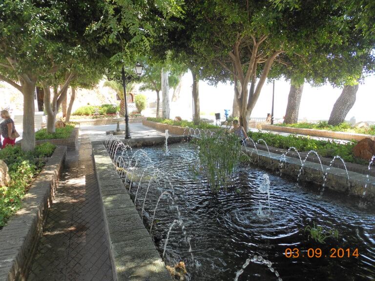 Mijas Springbrunnen unter Schatten spendenen Bäumen